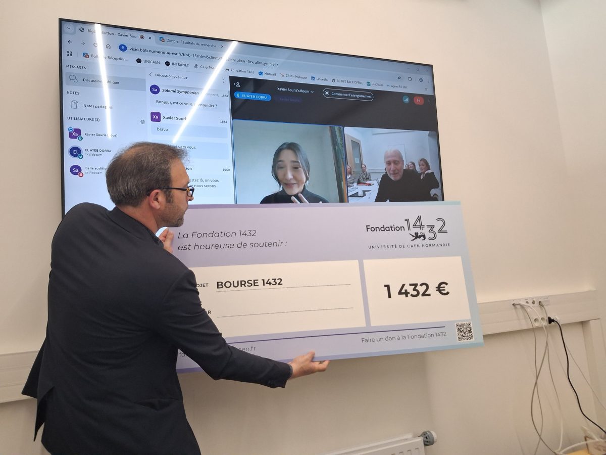 Photo de la lauréate en visioconférence avec un chèque géant en compagnie de Thierry Lobel.